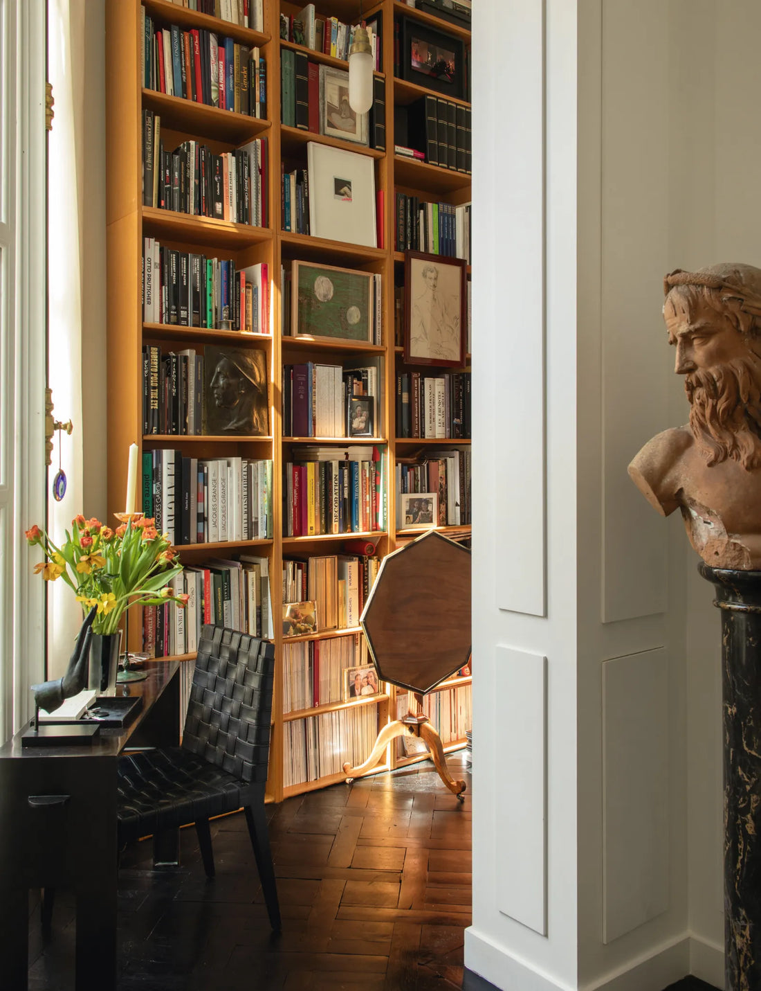 An 18th-century terracotta bust looks askance towards a patinated console by Eric Schmitt for Christian Liaigre and a Louis XVI folding tripod table